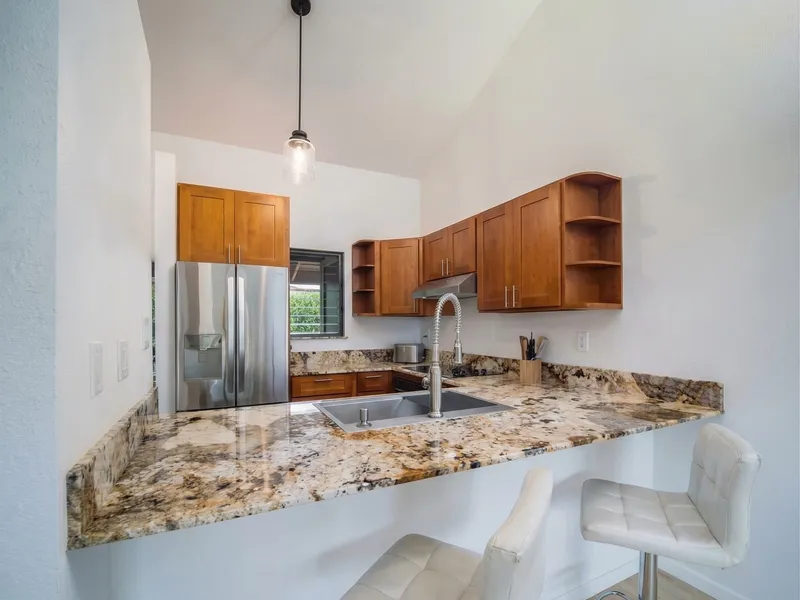 Kitchen remodel Maui — open plan with breakfast bar peninsula and pendant lighting